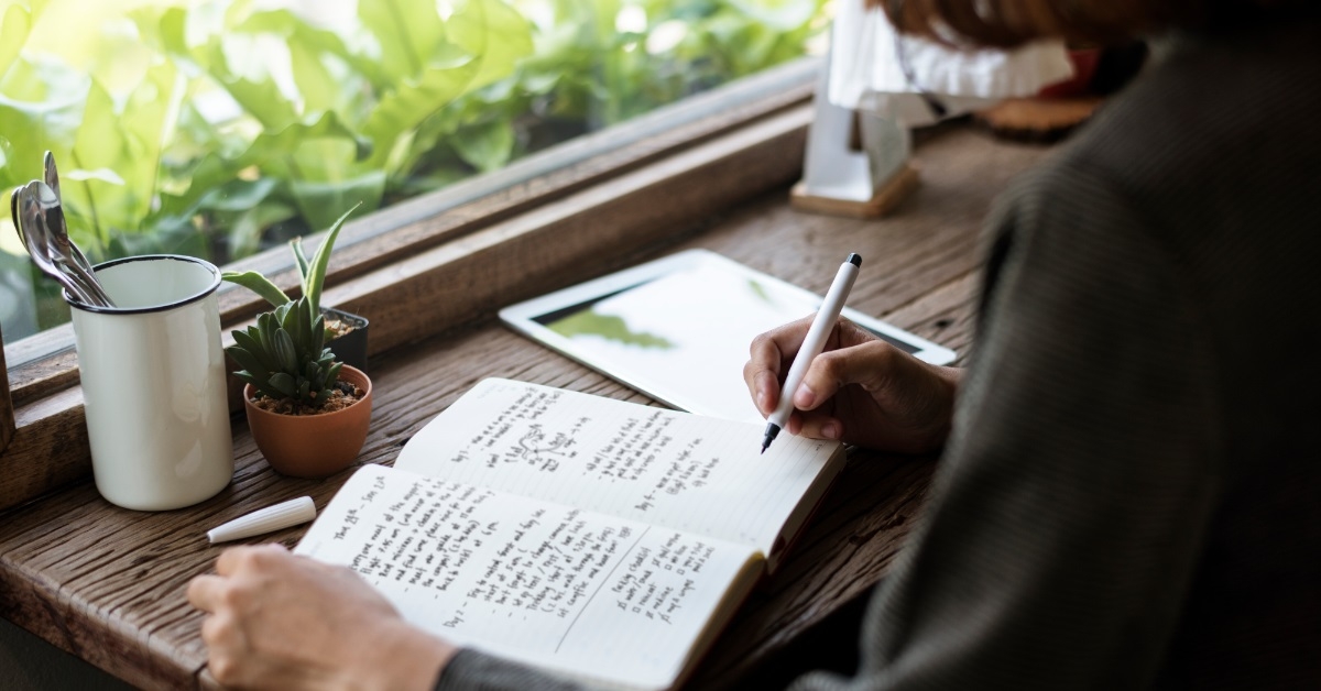 woman writing notes in journal