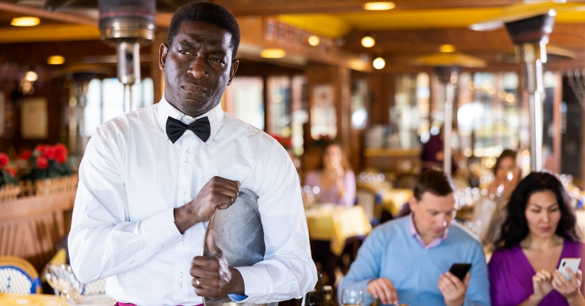 exhausted african american waiter with tray