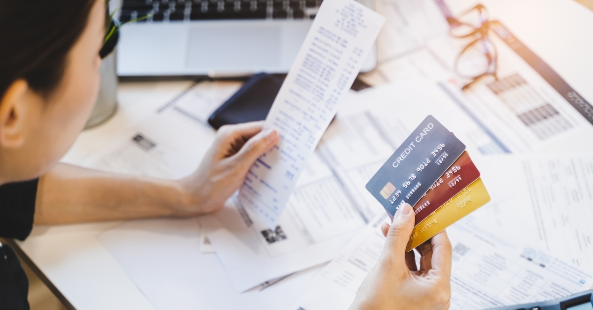 woman looking at many credit cards