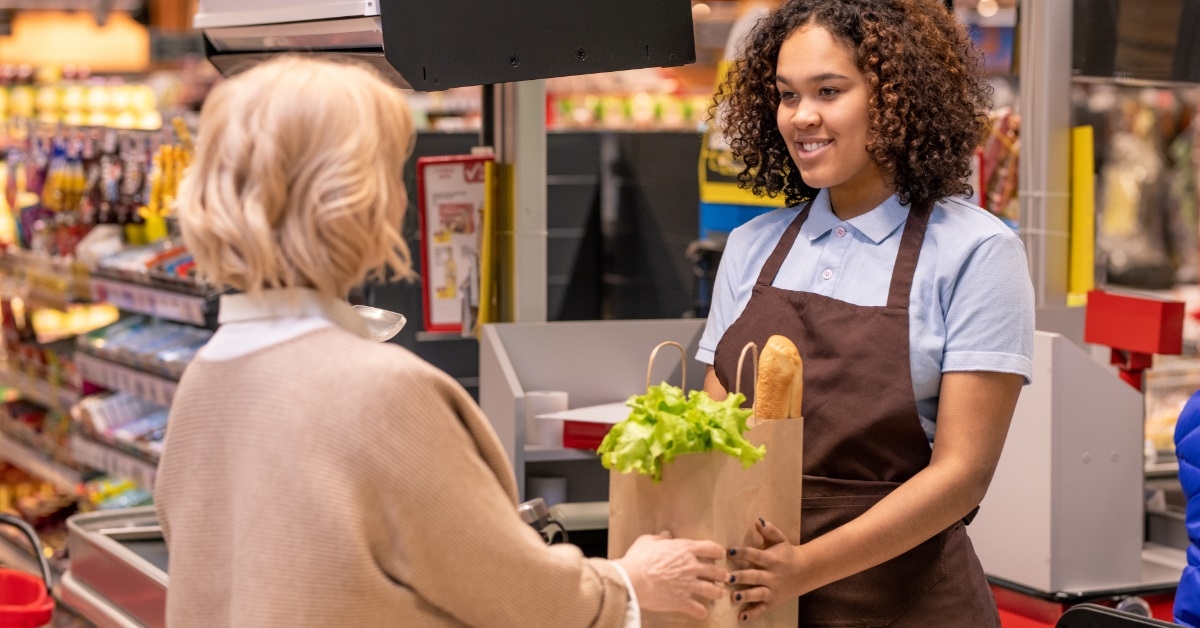 female cashier giving client groceries