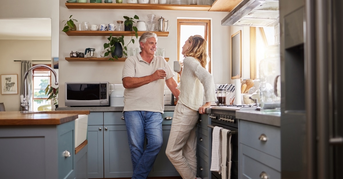 retired couple having coffee in kitchen