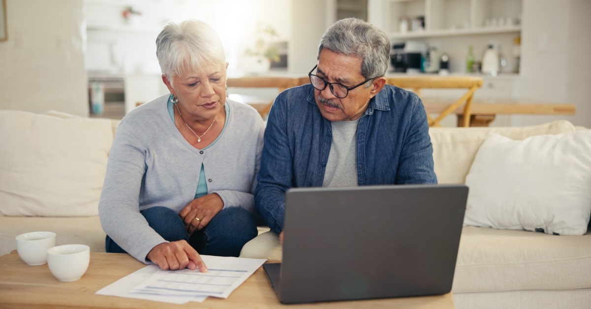 senior couple reviewing bills using laptop