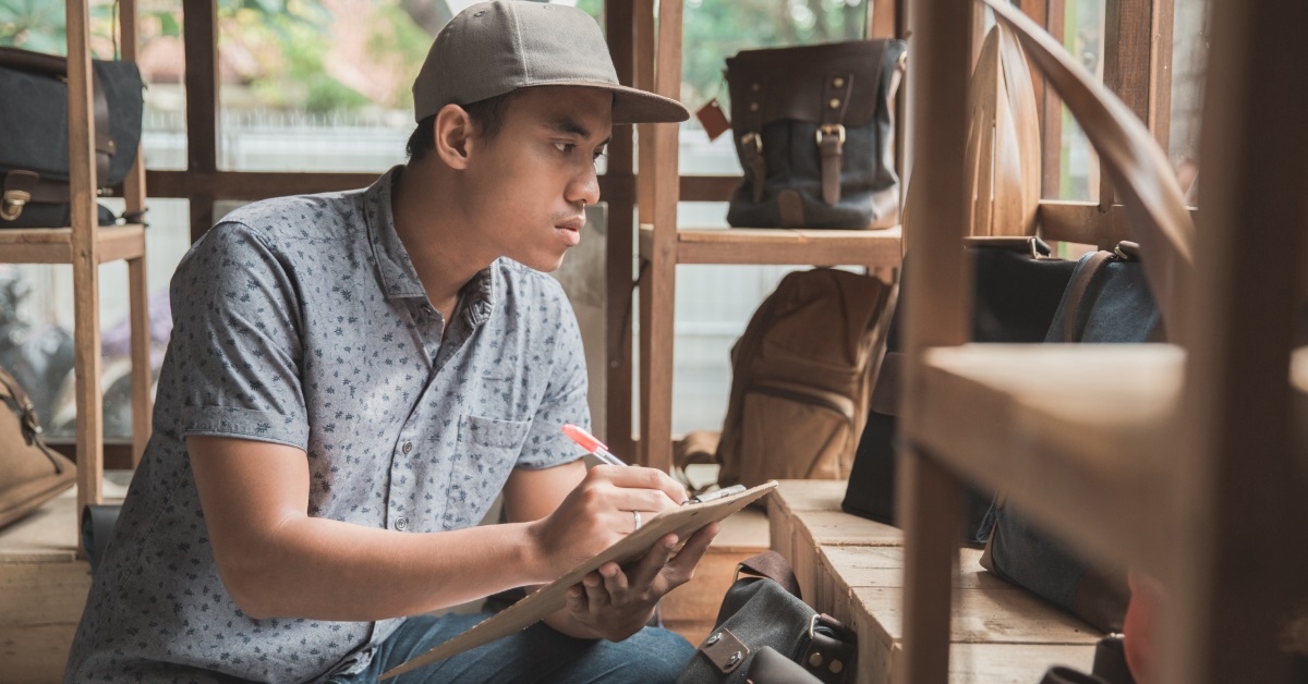 male store manager checking product list