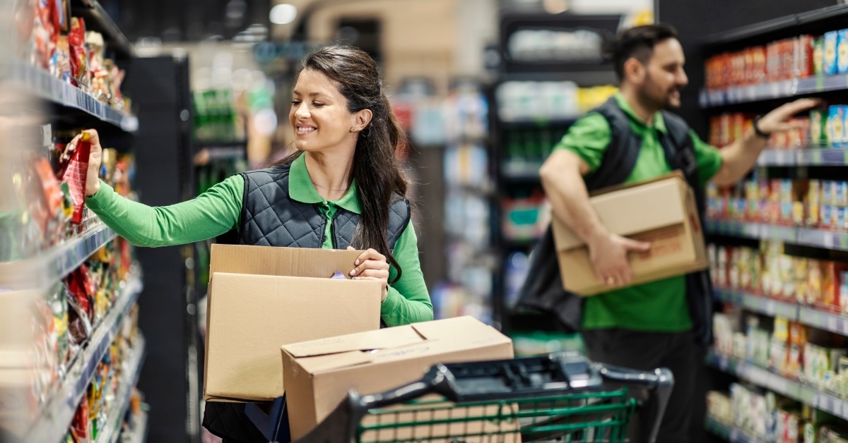 happy employees arranging groceries on shelves