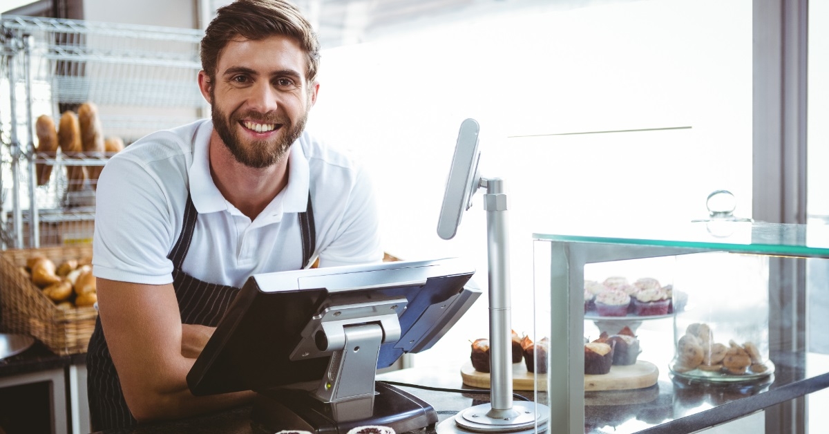 smiling worker posing behind counter