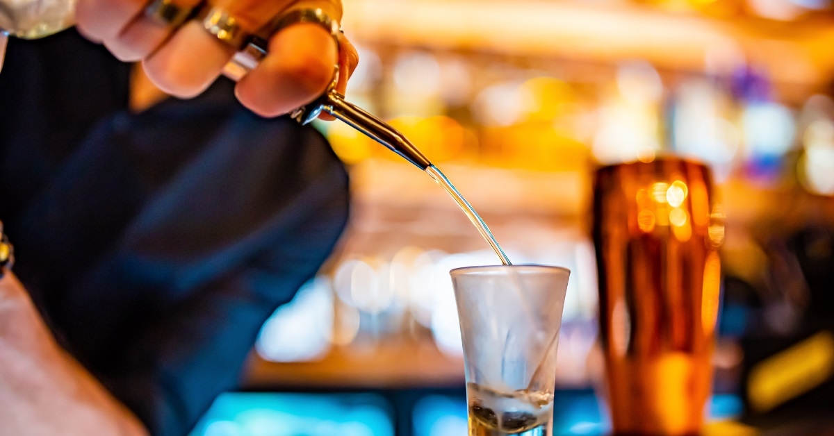 bartender pouring alcohol in shot glass