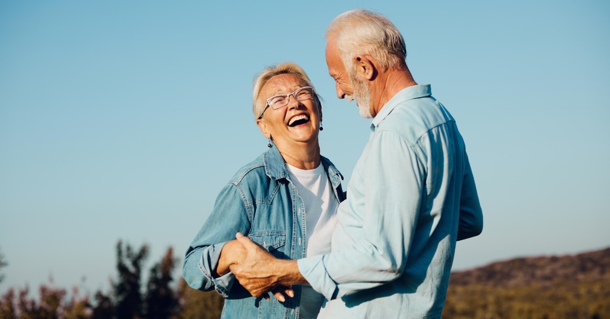 happy retired couple smiling outdoors