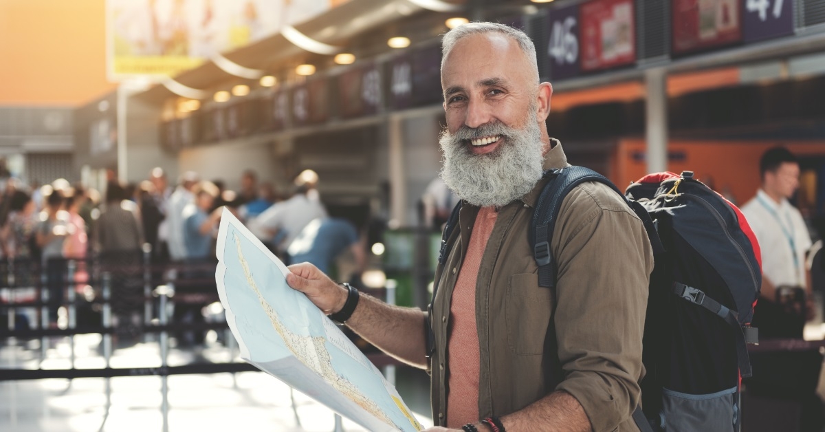 retired man reading map on vacation