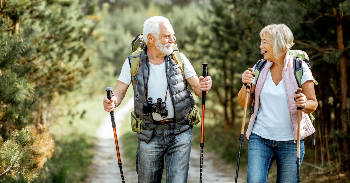 senior couple hiking with trekking sticks