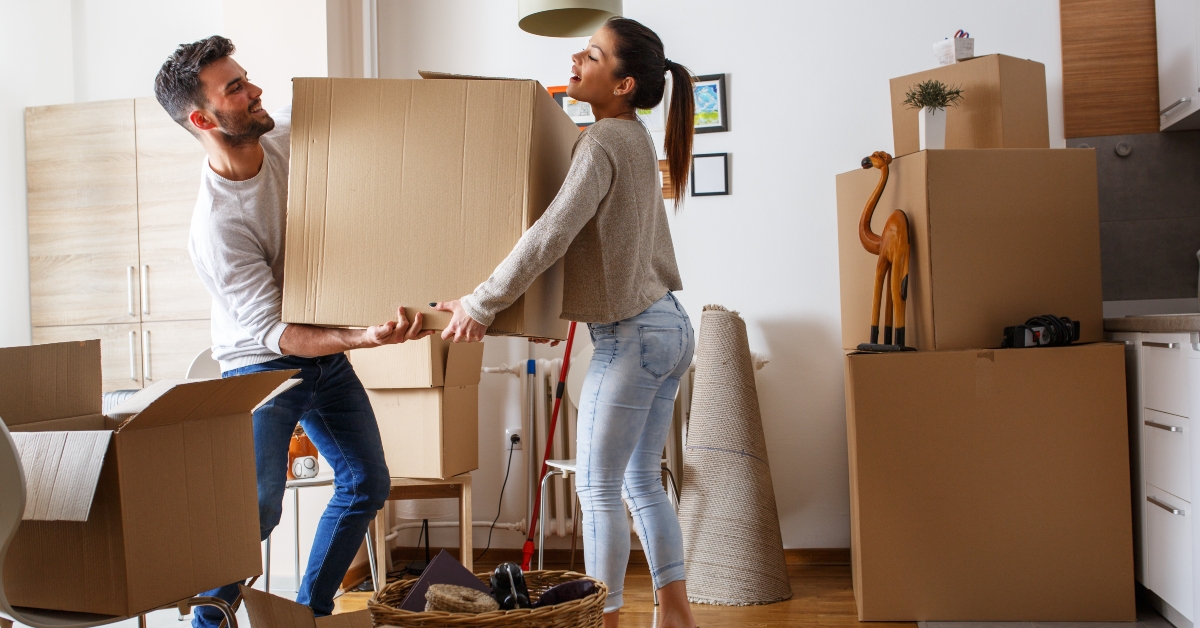 couple carrying big cardboard box