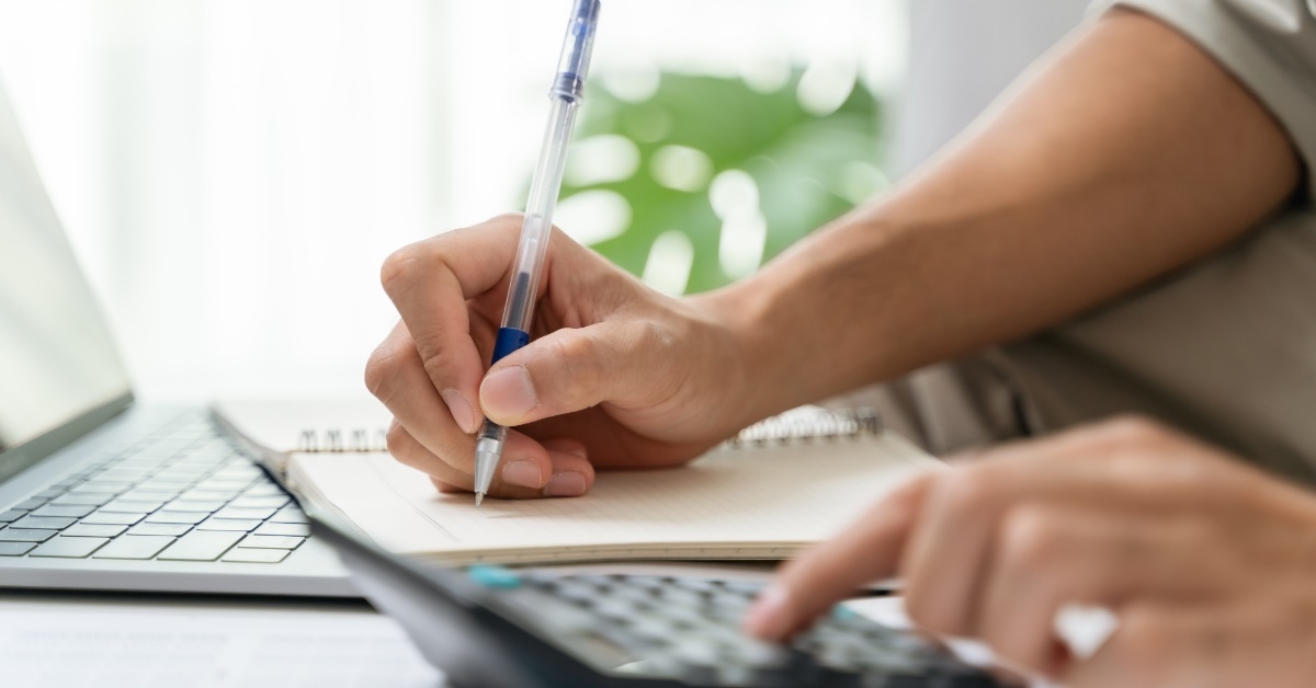 man making notes while reviewing taxes