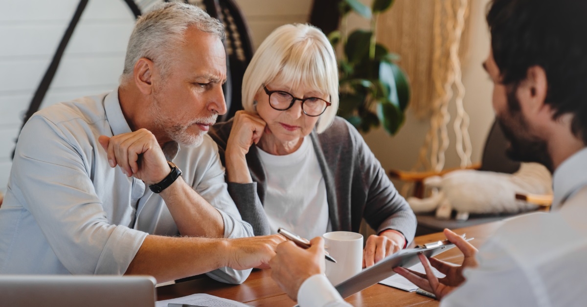 advisor explaining paper to senior couple