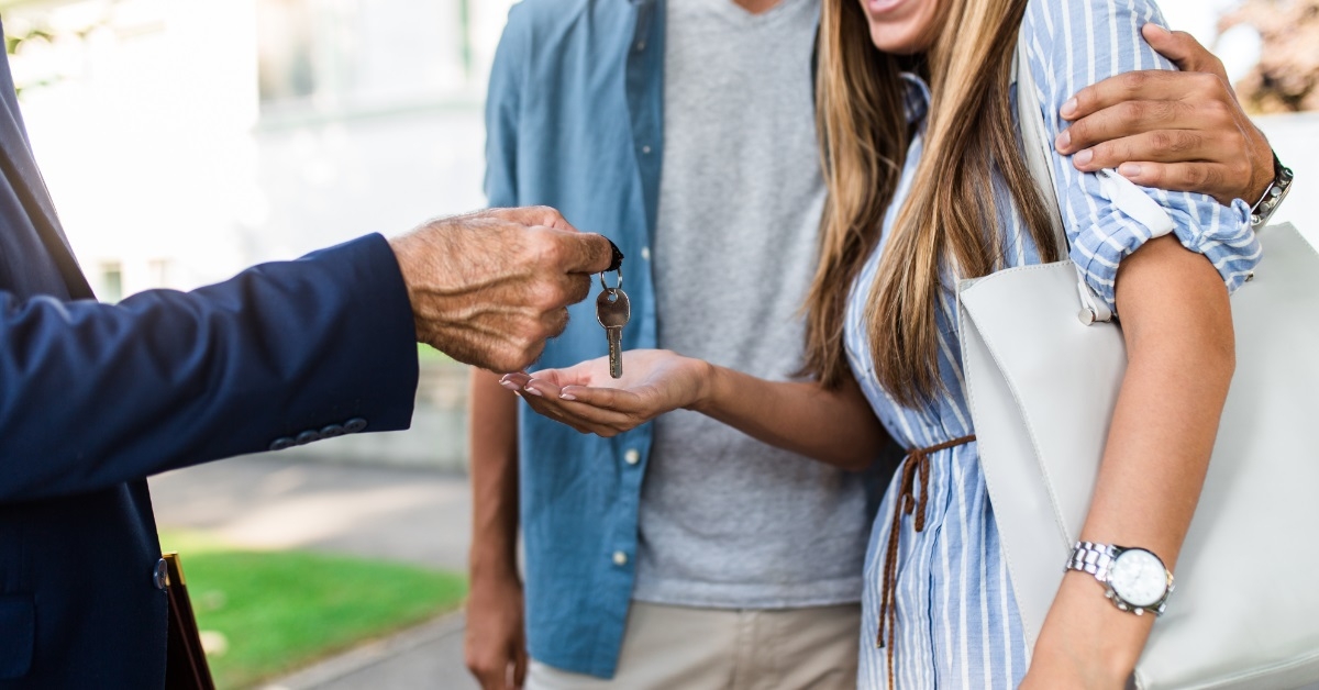 realtor giving house keys to couple
