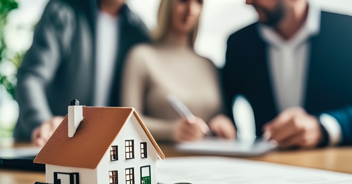 couple signing mortgage agreement with realtor