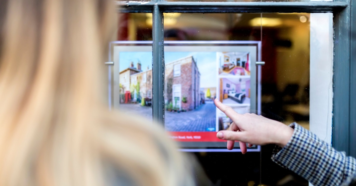 friends reading property advertisement in window