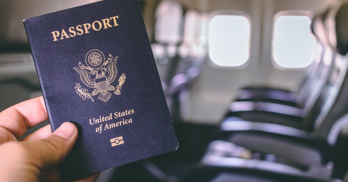 hand holding american passport in airplane