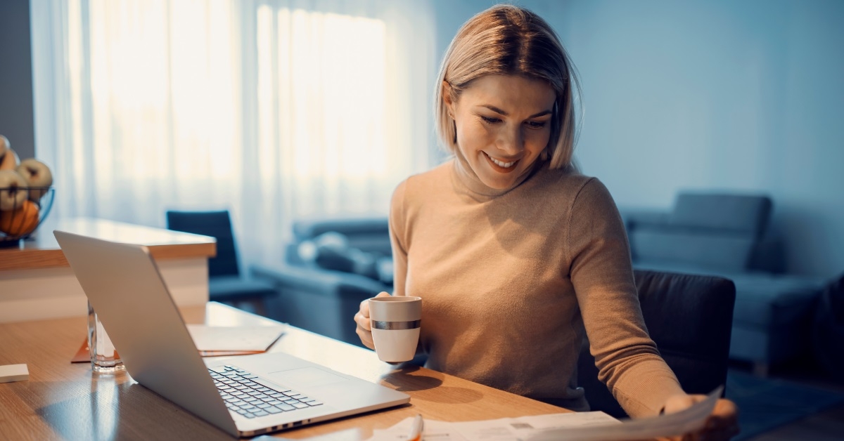 happy woman reviewing bills at home