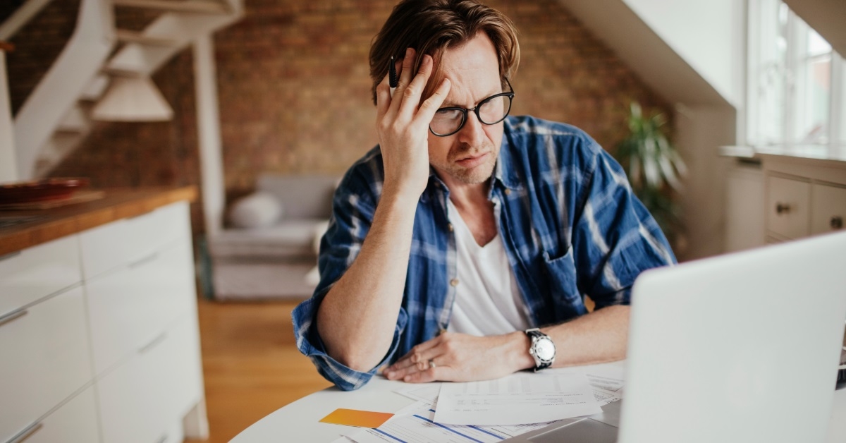 man stressed while reviewing bills