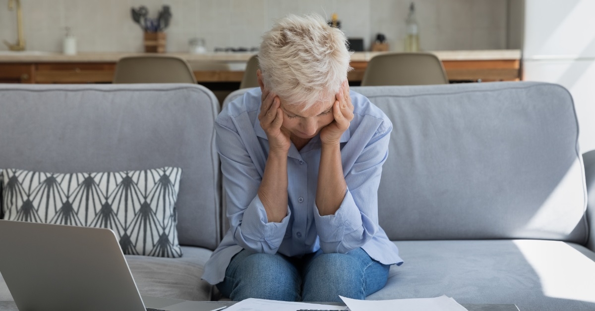 stressed senior woman reviewing bills