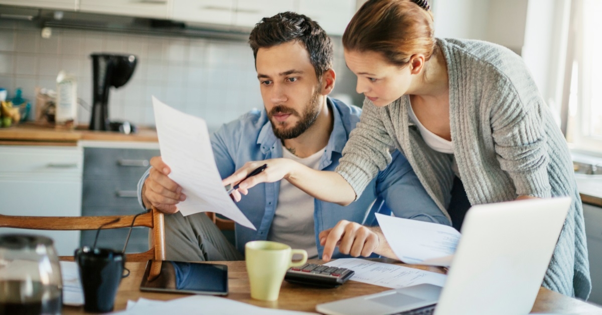 couple checking bills together in kitchen