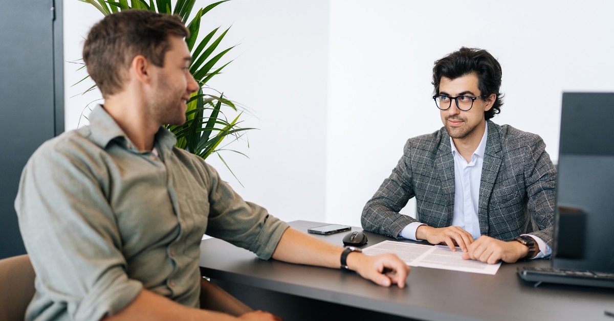 man consulting male broker at office