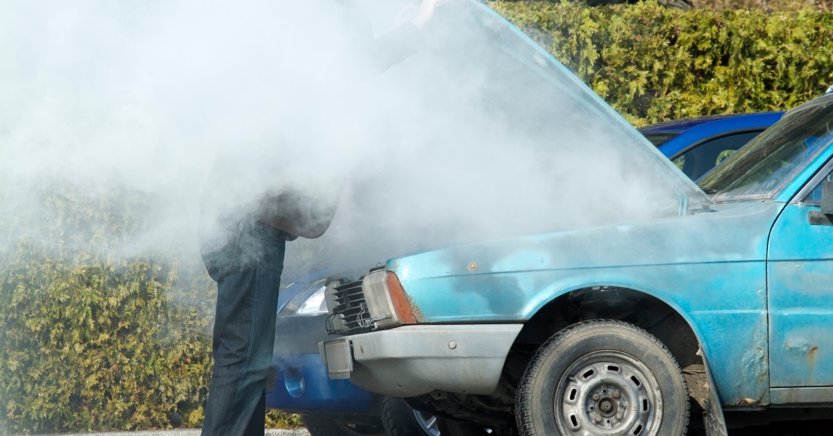 Man looking at car smoking engine