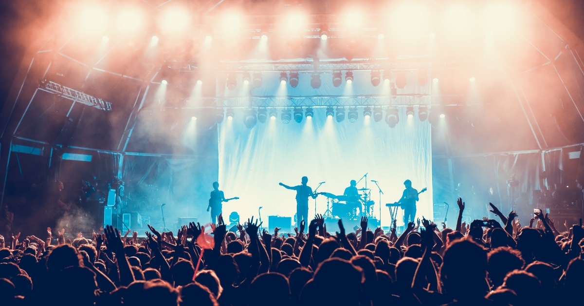 crowd waving hands at music concert