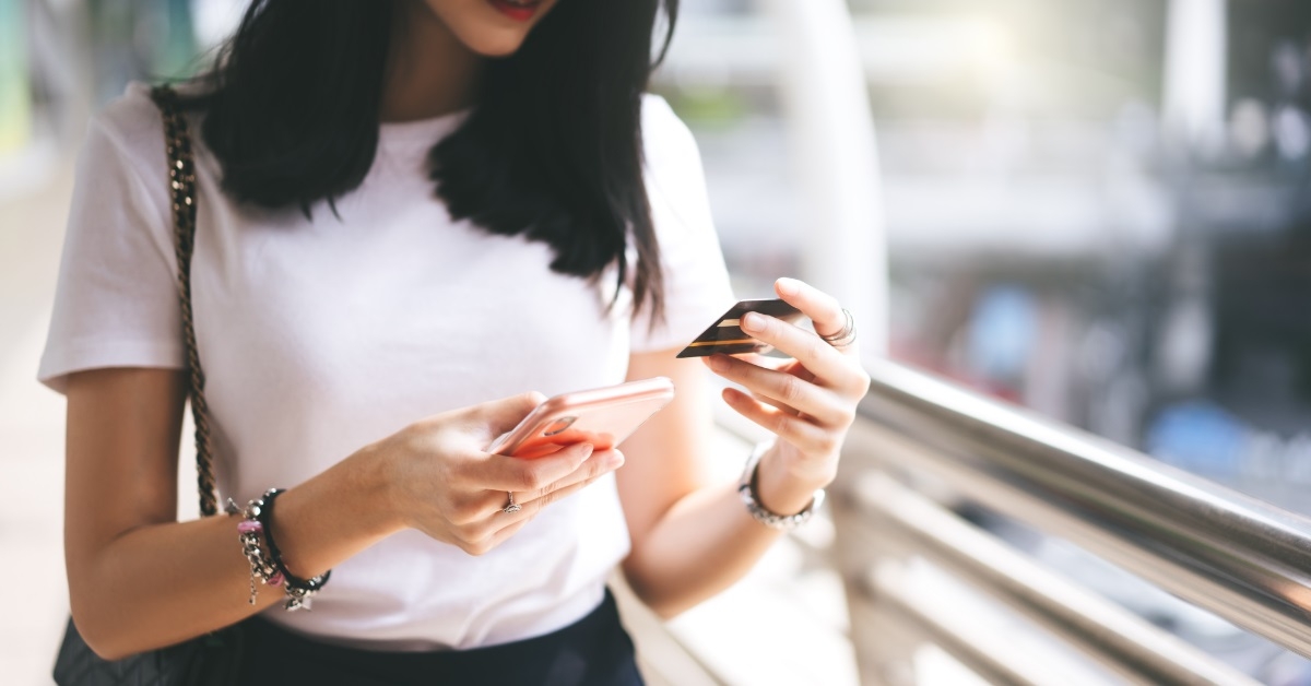 woman holding card shopping on smartphone