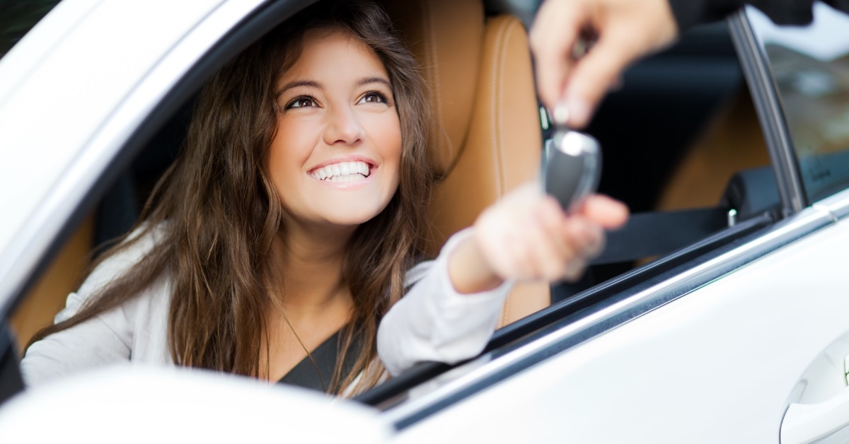 woman receiving new car keys