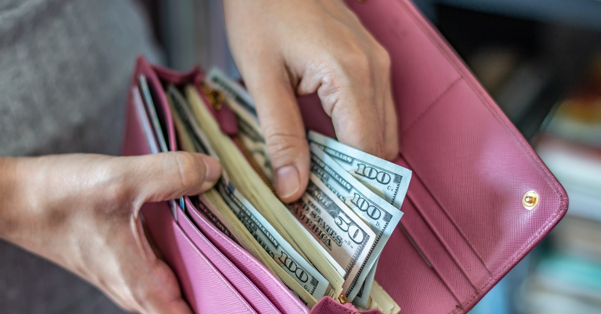 woman taking out dollars from wallet