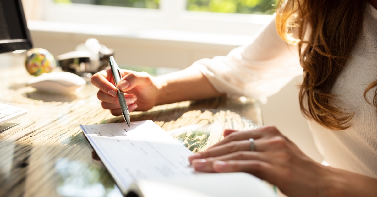 business woman signing cheque
