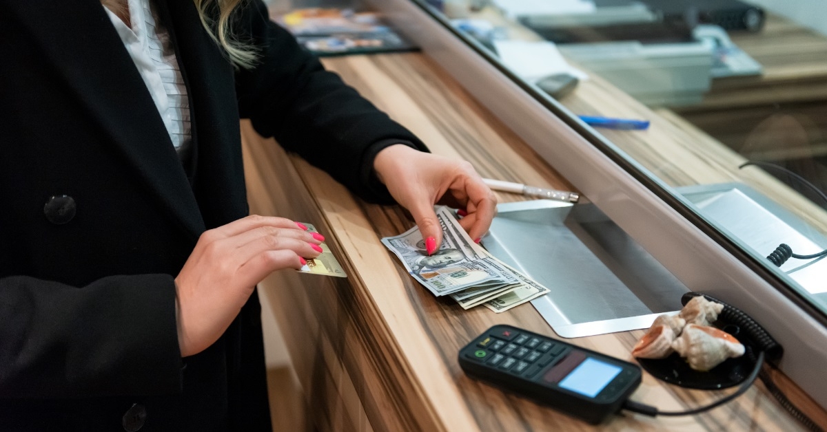 woman holding money at cash desk