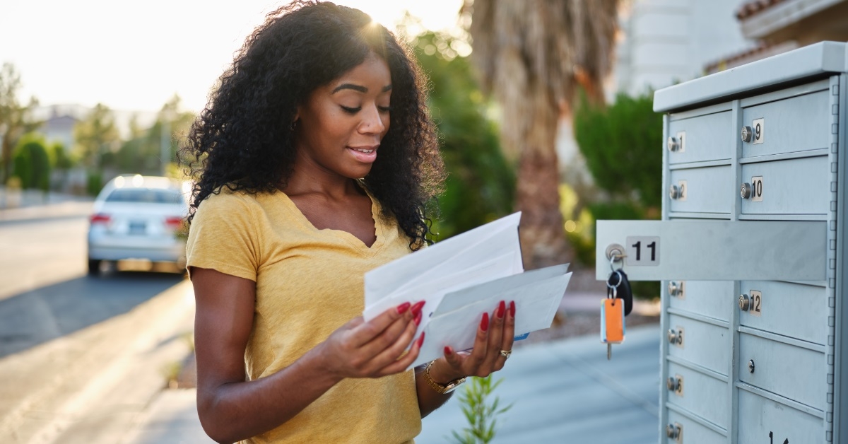 african american woman checking mail outdoors