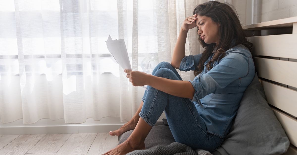 stressed woman holding financial papers