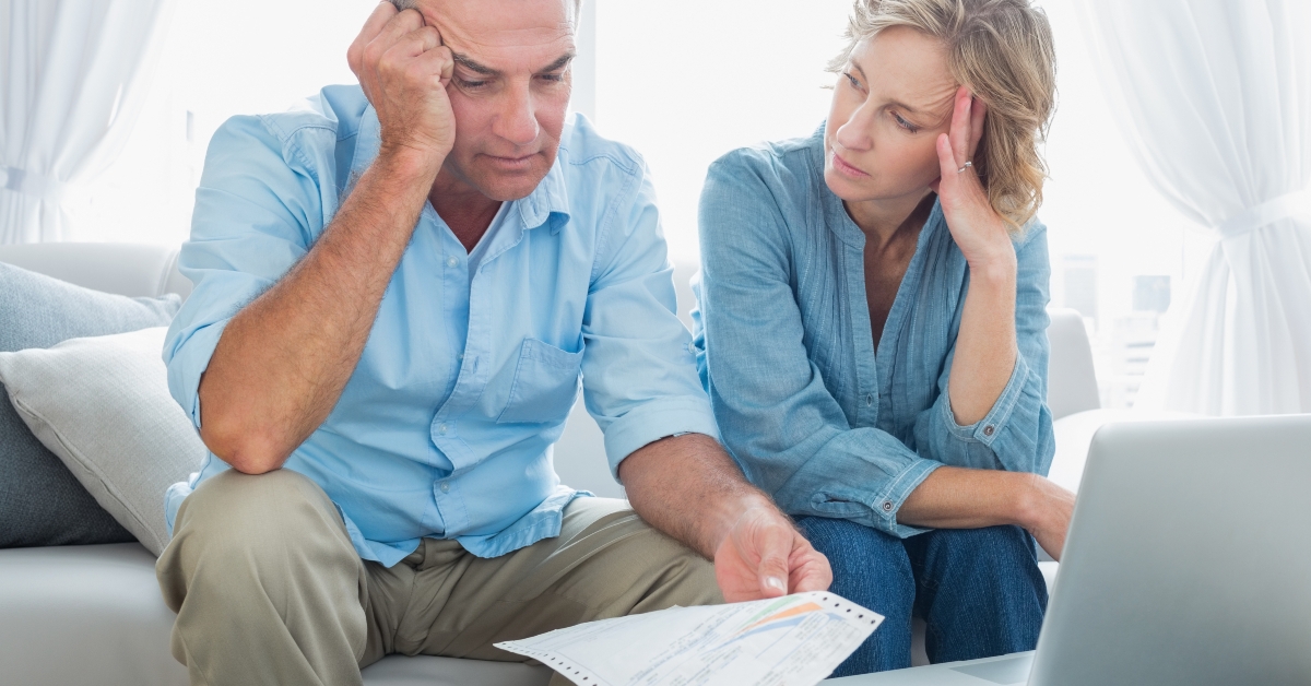 worried couple using their laptop