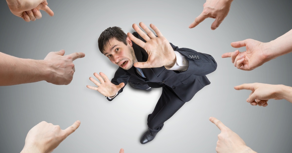 hands pointing at stressed businessman