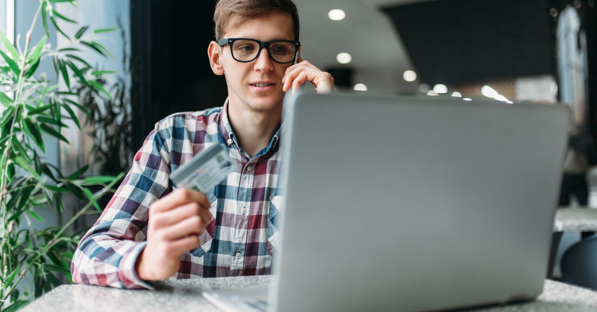man sits in a cafe with a laptop
