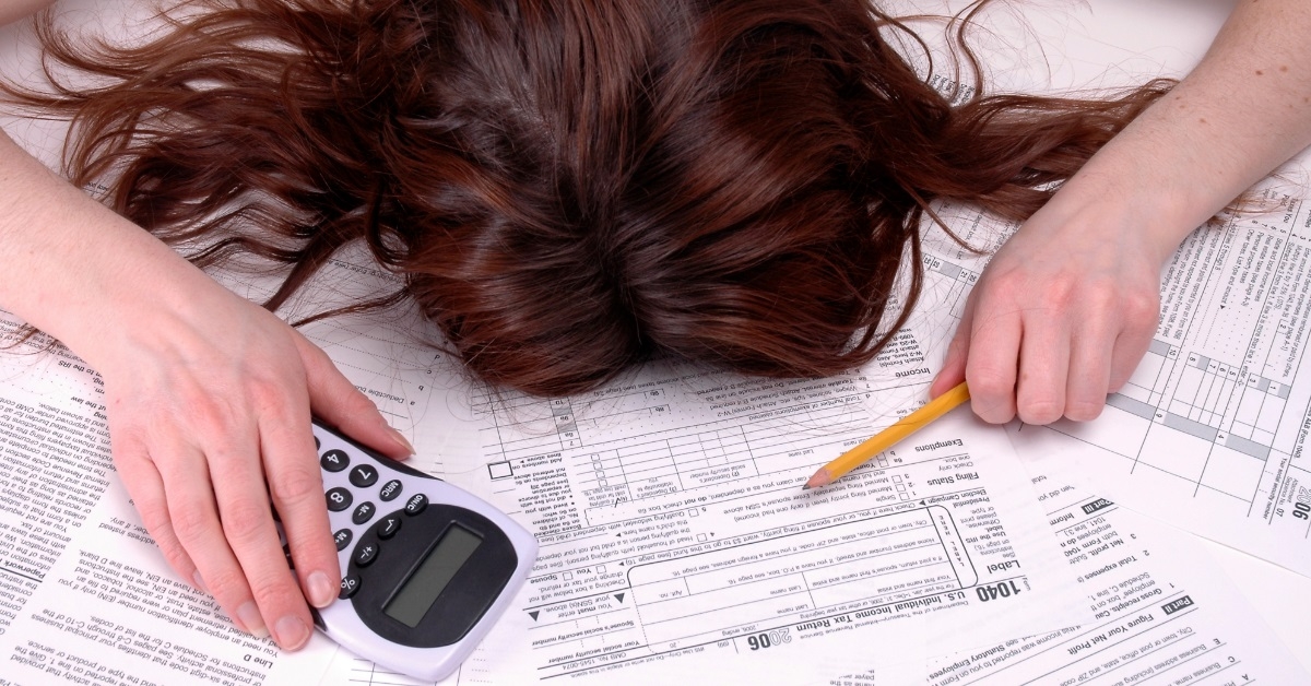 woman exhausted while calculating taxes