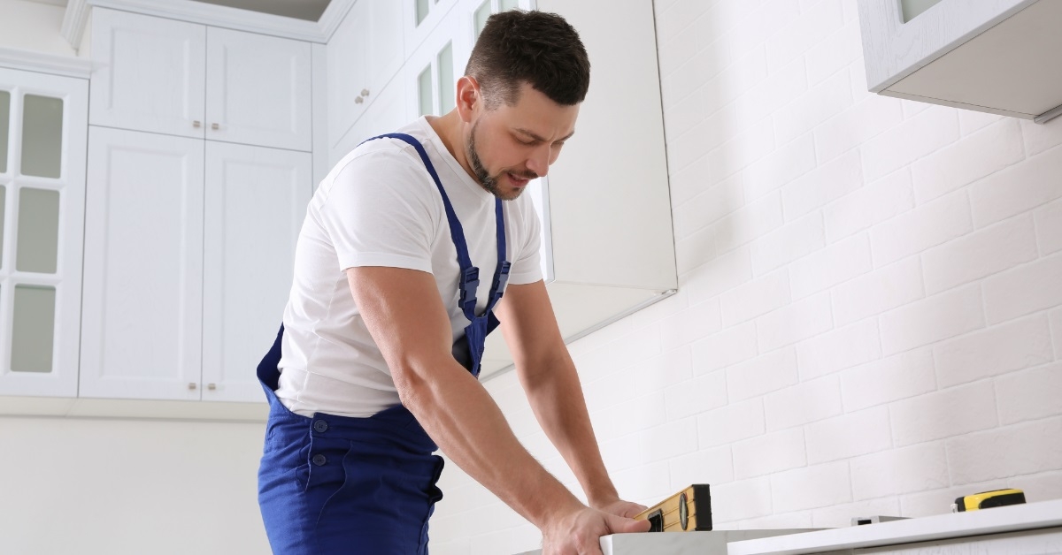 Worker measuring countertop with spirit level