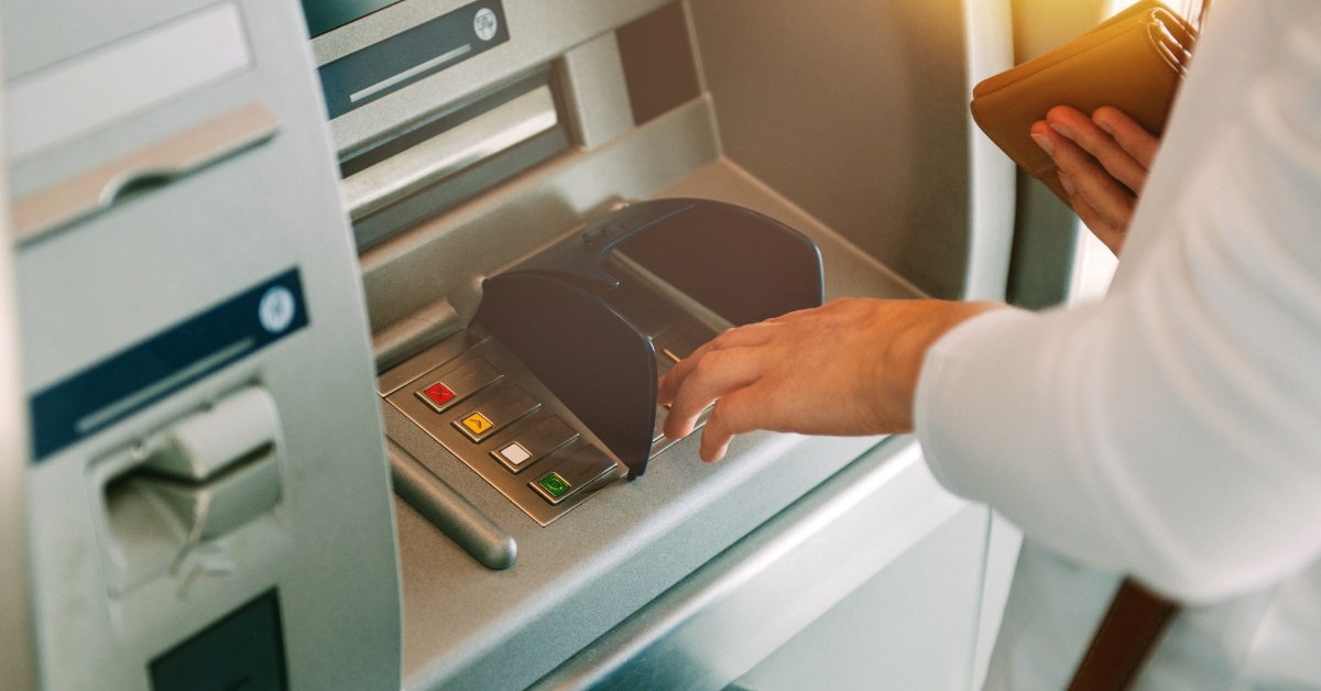 Woman using ATM holding wallet