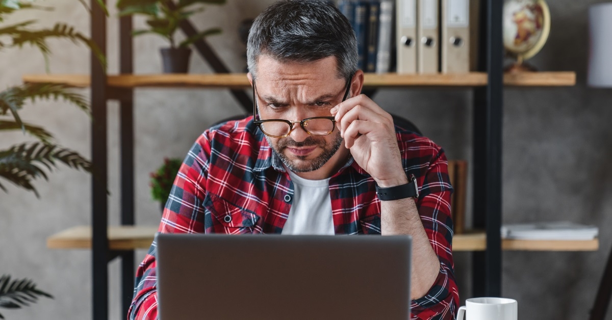 confused businessman looking at laptop screen