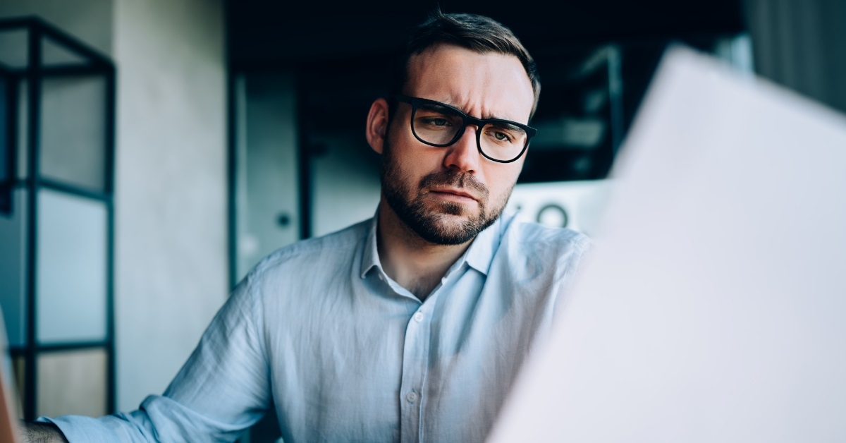 confused businessman reviewing financial report