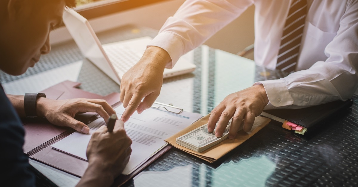 man signing contract with male investor