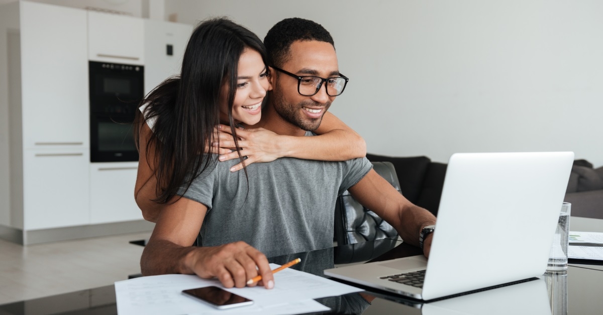 young couple analyzing budget using laptop