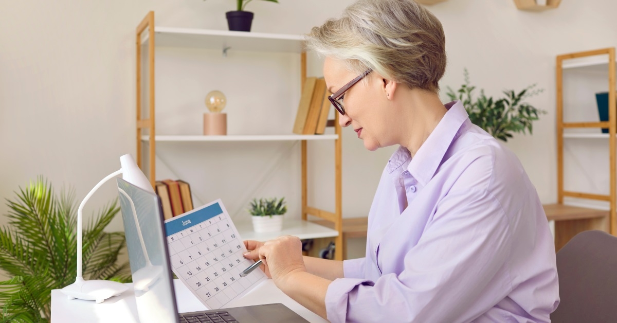senior business woman reviewing paper calendar