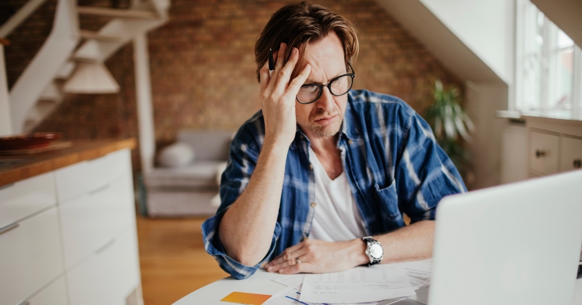 mature man reviewing bills using laptop