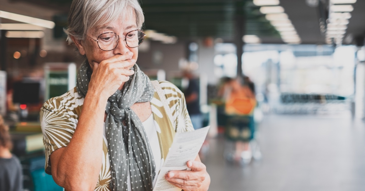 stressed senior woman reviewing grocery bill