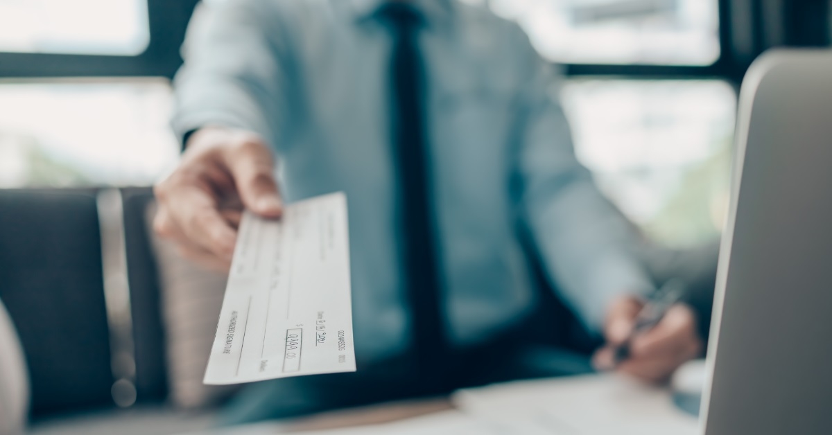 businessman giving cheque to client