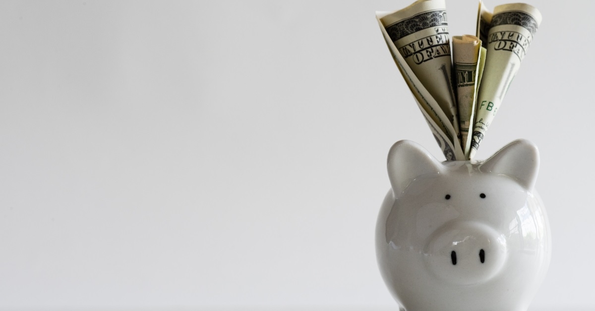 dollars stuffed into piggy bank