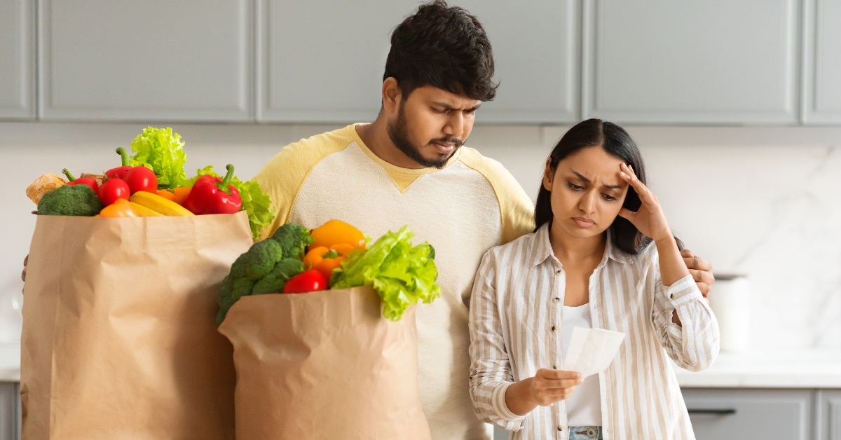 Frustrated couple checking grocery bill